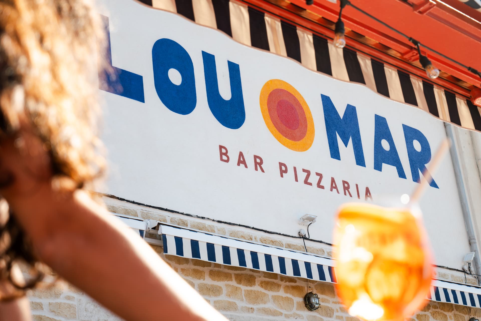 Enseigne Lou Mar Bar Pizzaria au-dessus de la terrasse